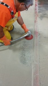 This photo shows the Terrazzo Mechanic grinding the edges (border) with a terrazzo base machine.